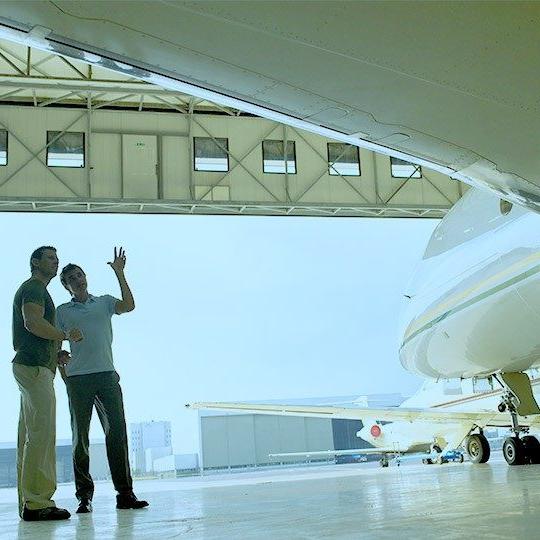 两名男子站在一架私人飞机旁讨论商务航空mro服务